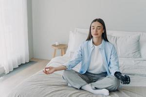 Meditation und Konzentration. Morgenroutine einer behinderten Frau mit künstlichen Cyber-Gliedmaßen. foto