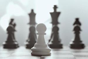 allein gegen alle, Schach weiße Sperrklinke gegen gegenüberliegende Armee auf grauem Hintergrund. foto