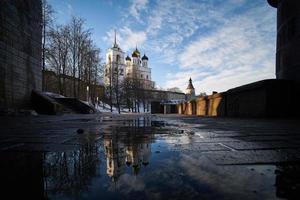 Dreifaltigkeitskathedrale im Pskower Kreml mit Reflexion im Wasser einer Frühlingspfütze. foto