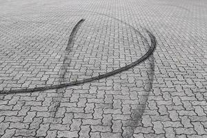 Schwarze Reifenspuren auf einer Kopfsteinpflasterstraße foto