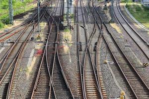 Mehrere Bahngleise mit Abzweigungen an einem Bahnhof perspektivisch und aus der Vogelperspektive foto