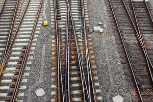 Mehrere Bahngleise mit Abzweigungen an einem Bahnhof perspektivisch und aus der Vogelperspektive foto