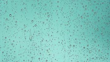 Regentropfen, die in Nahaufnahme ein Autofenster hinunterlaufen. foto