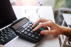 Geschäftsbuchhaltungskonzept, Geschäftsmann, der Taschenrechner mit Computerlaptop, Budget und Kreditpapier im Büro verwendet. foto