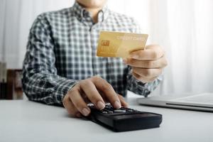 Geschäftsbuchhaltungskonzept, Geschäftsmann, der Taschenrechner mit Computerlaptop, Budget und Kreditpapier im Büro verwendet. foto