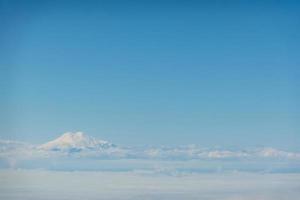 Luftaufnahme über Elbrus, Karatschai-Tscherkessien. Elbrus scheint durch die Wolken foto