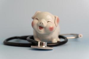 medizinisches stethoskop sparschwein geschäftskonzept versicherung investitionen gesundheitswesen und geld sparen. foto