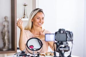 schöne natürliche Frau professioneller Schönheits-Vlogger oder Blogger Live-Übertragung von kosmetischem Make-up-Tutorial viraler Videoclip per Kamera, die in sozialen Medien geteilt wird foto