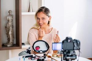 schöne junge bloggerin, die vlog-video mit make-up-kosmetik zu hause online-influencer auf social-media-konzept aufzeichnet. live-streaming viral foto