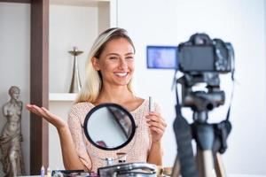 schöne junge bloggerin, die vlog-video mit make-up-kosmetik zu hause online-influencer auf social-media-konzept aufzeichnet. live-streaming viral foto