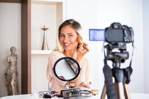 junge schöne blonde frau professionelle schönheit vlogger oder blogger aufnahme make-up-tutorial zum teilen in sozialen medien foto