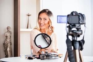 junge schöne blonde frau professionelle schönheit vlogger oder blogger aufnahme make-up-tutorial zum teilen in sozialen medien foto