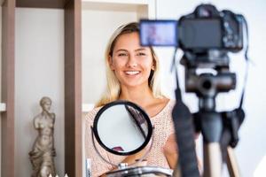 schöne junge bloggerin, die vlog-video mit make-up-kosmetik zu hause online-influencer auf social-media-konzept aufzeichnet. live-streaming viral foto