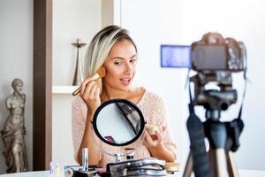schöne junge bloggerin, die vlog-video mit make-up-kosmetik zu hause online-influencer auf social-media-konzept aufzeichnet. live-streaming viral foto