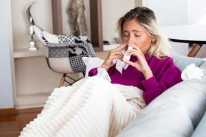 Frau hat Grippe und sie benutzt Nasenspray, um sich selbst zu helfen. Frau mit Nasenspray. Nasenspray gegen Erkältung. krank mit einer Rhinitis-Frau, die Nase tropft. Frau trägt Nasenspray auf foto