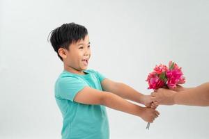 junger asiatischer junge gibt der frauenhand einen blumenstrauß. Internationaler Frauentag. foto