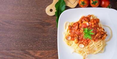Menü Pasta Spaghetti mit Frikadellen und Tomaten auf dem Tisch. Ansicht von oben foto