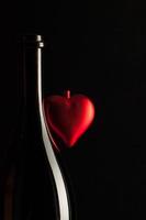 Silhouetten eleganter Weinflaschen mit rotem Herzen foto