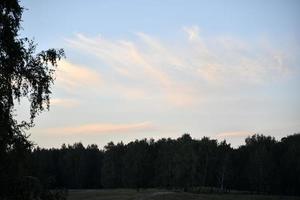 ein farbenfroher blau-rosa Sonnenuntergang an einem Sommerabend. schöner horizont mit sonnenuntergangssonne im sommer. schöne Sonnenuntergangsfarben und bunte Wolken. foto