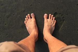 zwei Fuß am Strand. mit braunem schwarzen Sandstrand foto
