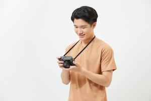 glücklicher junger asiatischer Hipster-Fotograf in lässiger Mode mit Vintage-Kamera-Freiheits-Lifestyle-Reisekonzept foto