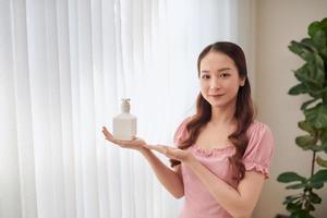 Porträt einer jungen Asiatin, die neue Produkte zeigt, während sie hinter dem Fenster steht. foto