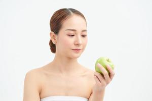 eine schöne Frau, die einen frischen grünen Apfel zum Essen hält foto