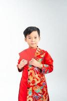 junger asiatischer Junge mit rotem Paketgeld foto