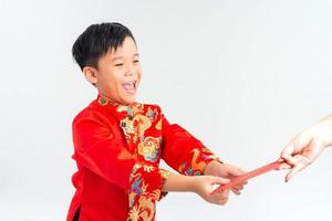 asiatischer vietnamesischer junge, der rotes papierpaket oder geld von einem anderen auf dem neujahrsfest des mondes erhält, mit traditionellem ao dai isoliert auf weißem hintergrund. foto