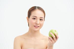 Konzept für gesunde Ernährung, Ernährung und Menschen - lächelnde junge Frau mit grünem Apfel zu Hause foto