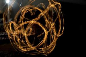 Kreise aus Feuer. Flammenlinien. Aufnahme einer Feuershow mit langer Verschlusszeit. foto