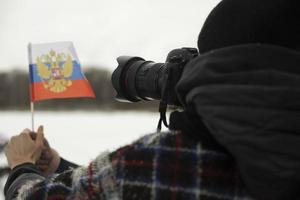 Fotograf schießt Flagge Russlands. kleine Fahne in der Hand. foto