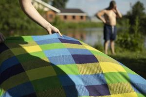Entspannen Sie sich im Sommer am Strand. farbige Decke am See. Details zum Picknick im Park. foto