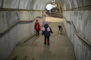 Zwei Kinder gehen durch den Tunnel. Kinder gehen mit Hund in der Stadt spazieren. zwei Mädchen im Vorschulalter. foto