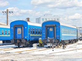 Blaue Waggons vor dem Hintergrund des Winterparkplatzes des Bahnbetriebswerks. foto