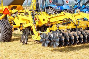 ein Fragment der Kupplung einer mehrreihigen Scheibenegge mit einem Traktor an einem Sommertag. foto