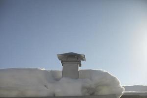 Schornstein auf dem Dach im Winter ohne Rauch. Schnee auf dem Dach. Details des Hauses im Dorf. foto