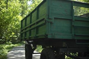 grüner Traktoranhänger. Wagen auf Rädern. Seite des Anhängers. Körper des Transports. foto