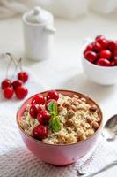 Herkulesbrei mit Haselnüssen, Müsli und Kirschbeeren foto