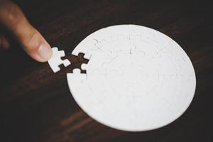 Geschäftsfrau-Personenhand mit Puzzleteilidee für Strategie und Lösung. Closeup Teil von zwei weißen Puzzles verbinden sich. konzept des gemeinsamen zusammenarbeitserfolgs teamwork-problem unternehmensteam. foto