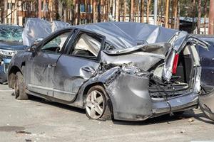 Kaputtes Auto nach einem Verkehrsunfall auf dem Parkplatz einer Reparaturstation. Karosserieschadenwerkstatt im Freien. Verkauf von Versicherungsautos. Unfall auf der Straße, Auto nach einer Kollision in der Stadt. foto