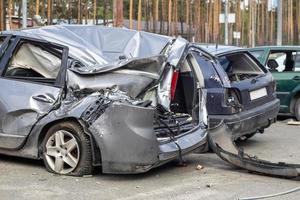 Kaputtes Auto nach einem Verkehrsunfall auf dem Parkplatz einer Reparaturstation. Karosserieschadenwerkstatt im Freien. Verkauf von Versicherungsautos. Unfall auf der Straße, Auto nach einer Kollision in der Stadt. foto