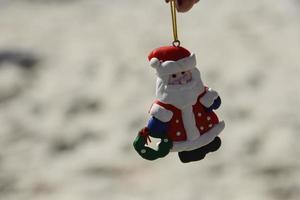 Weihnachtsmann-Puppe mit verschwommenem Strandhintergrund foto