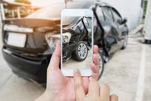 frau hält mobiles smartphone, das autounfall fotografiert