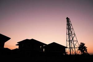 Silhouette Ramme auf Hausbau Baustelle mit Sonnenuntergang Himmel foto