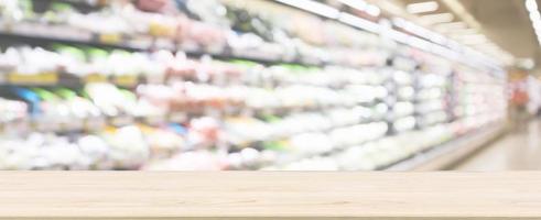 holztischplatte mit supermarkt-lebensmittelgeschäft verschwommener defokussierter hintergrund mit bokeh-licht foto