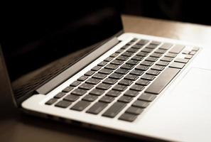 offener laptop mit schwarzem bildschirm auf modernem holzschreibtisch foto