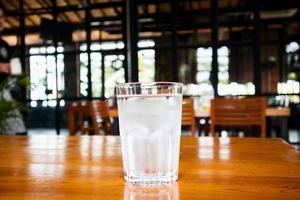 Glas Mineralwasser auf Holztisch im Restaurant foto