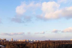 Sonnenunterganghimmel mit Wolken über Stadtpark und Häusern foto