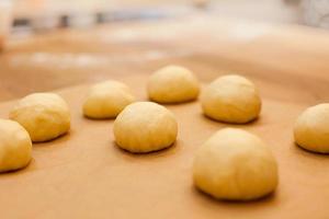 rohe hausgemachte Brötchen auf Küchentisch in der Herstellung foto